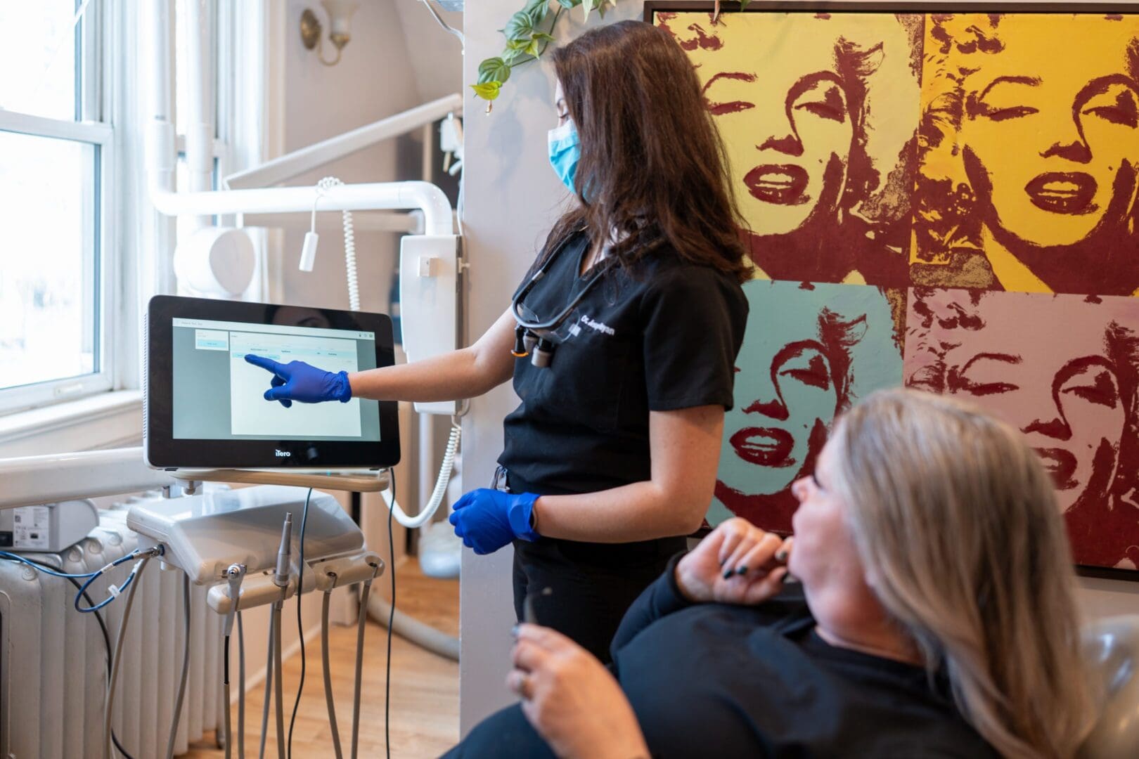 Dentist showing patient information on screen.